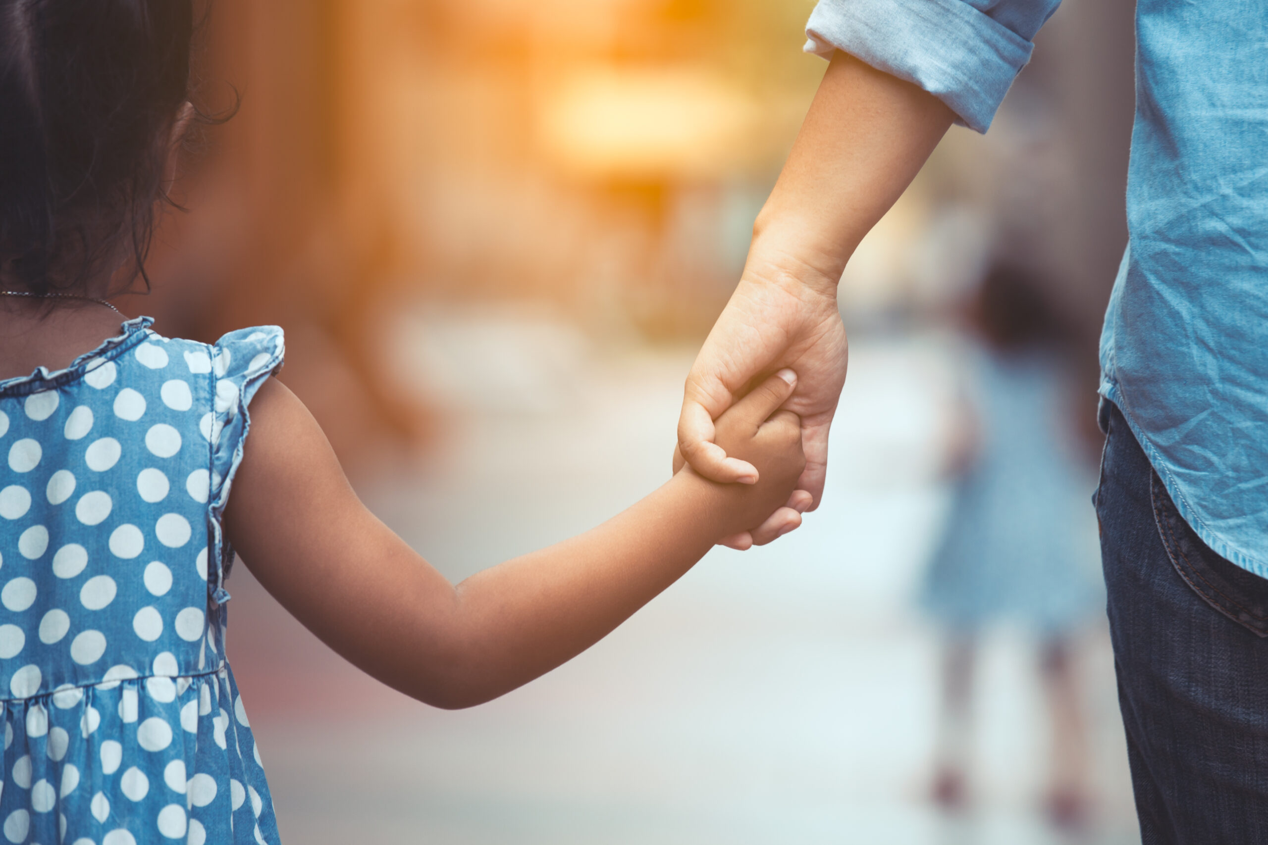 Mother-and-daughter-holding-hands-scaled