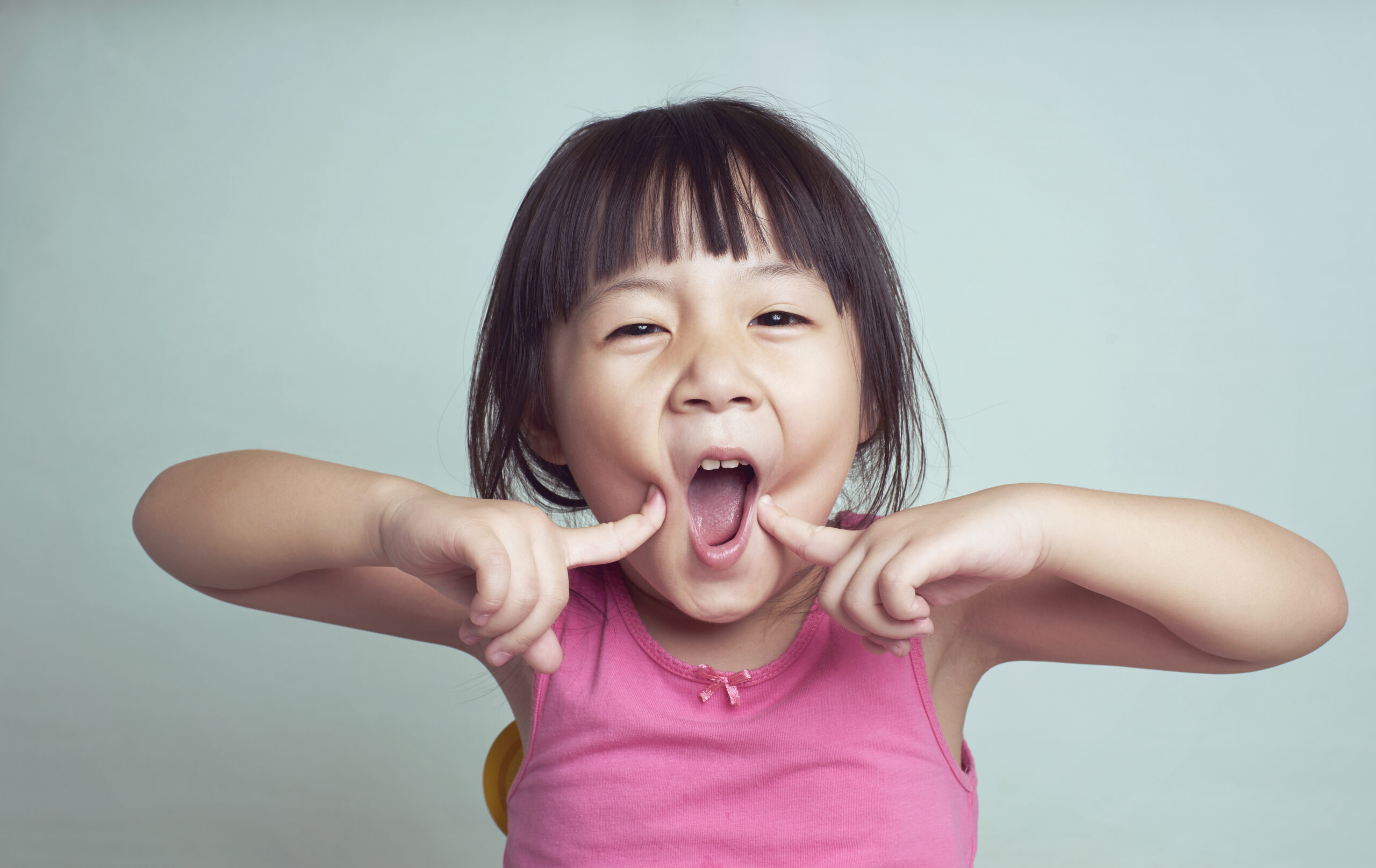 Playful-portrait-of-young-girl-smiling-scaled